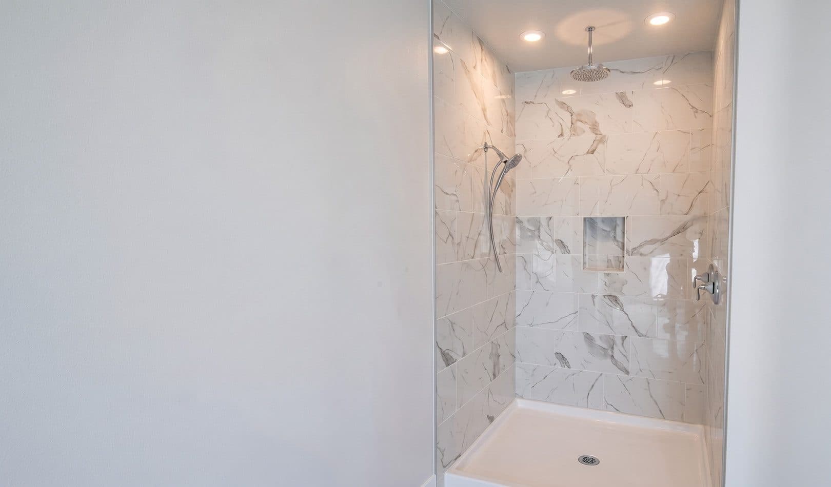Bathroom with marble walls and walk-in shower